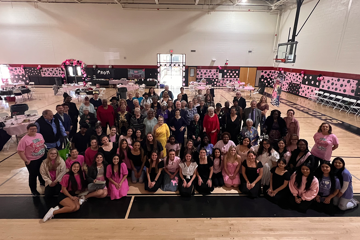 Group photo of 50+ people posed in gym 